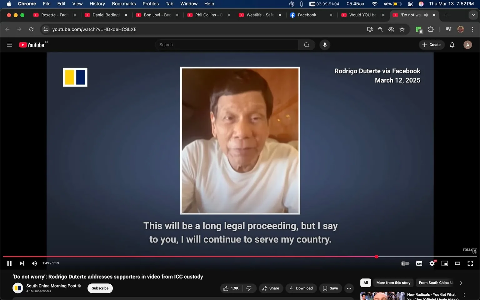 The image shows a video still featuring a man speaking directly to the camera. He appears to be in a casual setting, possibly indoors, with a warm, soft lighting that creates a relaxed atmosphere. The man is wearing a plain white t-shirt and has short, dark hair that is styled neatly. His facial expression is serious, and he seems to be addressing an audience with a focused demeanor.

To the left of the man, there is a blue and yellow flag-like graphic, which could represent a country or organization, but its specific meaning is not clear from the image alone. The background is a muted gradient of blue, which helps to emphasize the subject in the foreground.

Below the man's image, there is a caption that reads: "This will be a long legal proceeding, but I say to you, I will continue to serve my country." This text is presented in a clear, white font against the blue background, making it easily readable.

In the bottom section of the image, there are various interface elements typical of a video player, including a play bar, volume control, and options to like, share, or save the video. The video is attributed to "Rodrigo Duterte via Facebook" and is dated March 12, 2025. The source of the video is indicated as "South China Morning Post," which is displayed with a logo and subscriber count.

Overall, the image captures a moment of a video message from the man, who appears to be addressing a serious topic, likely related to legal matters, while conveying a sense of commitment to his country. The setting and visual elements contribute to the overall tone of the message.