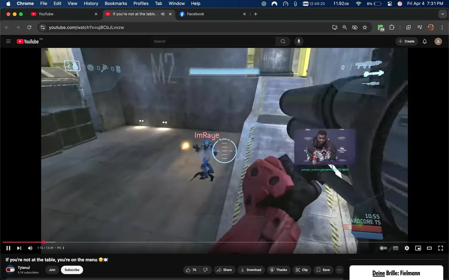 The image shows a scene from a video game, specifically a first-person shooter, likely from the "Halo" series. The player is in a virtual environment that appears to be a futuristic, industrial setting with concrete walls and a metallic floor. 

In the foreground, a character is holding a weapon, which is likely a gun, with a red and black design. The character's hand is prominently displayed, gripping the weapon tightly. The character appears to be wearing armor, which is red with some black accents. 

On the screen, there is a blue character, possibly an enemy or another player, depicted in a crouching position and moving away from the player. The blue character is wearing armor that is predominantly blue, with some details that suggest a futuristic design. 

Above the blue character, there is a health bar or status indicator, which is circular and displays a health percentage. The name "ImRaye" is visible above the blue character, indicating the player's username. 

In the upper right corner of the screen, there is a small video overlay of a person, who appears to be a male, wearing a dark jacket with a hood. He is sitting in front of a backdrop that includes logos, possibly related to a gaming event or brand. The overlay includes text that reads "swehyin_brohan just went BACK TO BACK," suggesting a commentary or chat feature related to the gameplay.

The background of the scene is a gray concrete wall with some lighting fixtures, and there are yellow hazard stripes on the floor, indicating a caution area. The overall atmosphere is tense and action-oriented, typical of a competitive gaming environment. 

The video is being played on a YouTube interface, as indicated by the player controls at the bottom, which include options to like, share, download, and subscribe. The title of the video is visible above the player controls, reading "If you're not at the table, you're on the menu." The video is currently at 1 minute and 16 seconds into a total length of 13 minutes and 49 seconds. 

The browser interface at the top shows that the video is being viewed on Chrome, with tabs open for YouTube and Facebook. The time displayed on the browser indicates it is 12:49 PM. 

Overall, the image captures a dynamic moment in a video game, with elements of player interaction, commentary, and a competitive atmosphere.