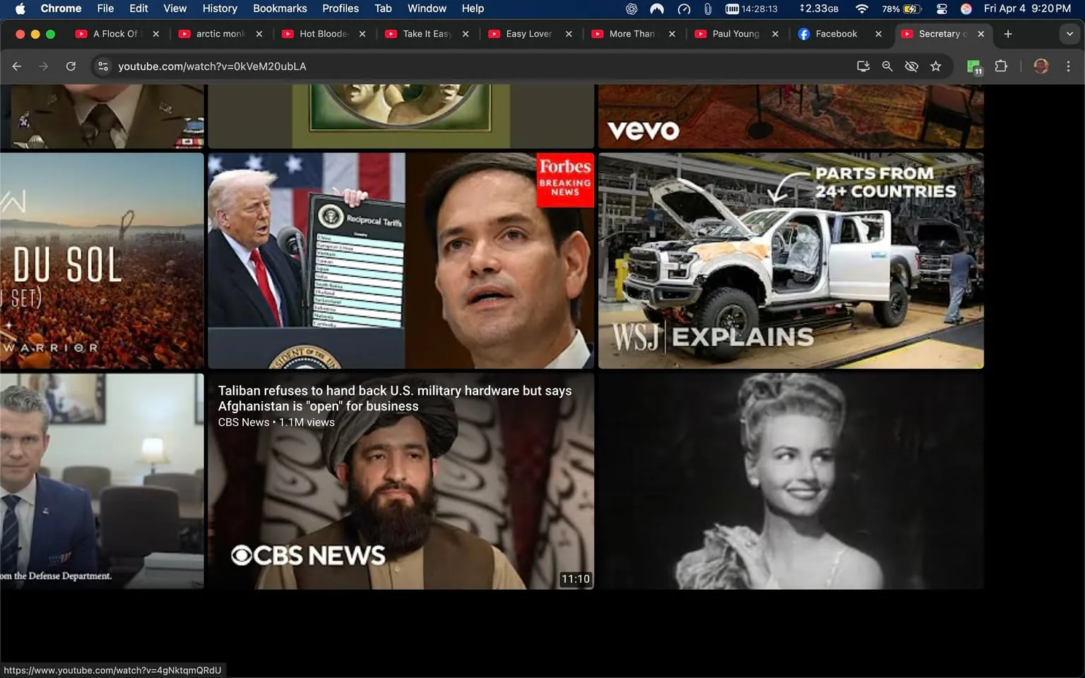 The image displays a collage of various video thumbnails from a web browser, likely a news or media platform. 

1. **Top Row:**
   - **Left Thumbnail:** Features a large crowd at a music festival or event, with the text "WARRIOR" and "SOL" visible. The background is filled with people, suggesting a lively atmosphere.
   - **Middle Thumbnail:** Shows a man, possibly a politician, speaking at a podium with an American flag in the background. He is holding a sign that reads "Reciprocal Tariffs." The man is wearing a suit and has a serious expression.
   - **Right Thumbnail:** Displays a close-up of a man, possibly a politician, with a concerned expression. He is wearing a suit and tie, and the thumbnail is labeled "Forbes Breaking News."

2. **Bottom Row:**
   - **Left Thumbnail:** Features a man in a military uniform sitting at a desk, with a caption indicating he is from the Defense Department. The setting appears to be an office or formal meeting room.
   - **Middle Thumbnail:** Shows a man with a beard and traditional attire, possibly a Taliban representative, with the caption "Taliban refuses to hand back U.S. military hardware but says Afghanistan is 'open' for business." The background suggests a formal setting, possibly an interview or press conference.
   - **Right Thumbnail:** Displays a vintage black-and-white image of a woman smiling, dressed elegantly, possibly from a past era. The image has a nostalgic feel.

3. **Additional Elements:**
   - The browser interface includes tabs for various YouTube videos, with titles like "A Flock Of..." and "Hot Blooded," indicating a mix of music and news content.
   - The overall layout suggests a news aggregation or video streaming service, with a focus on current events and political commentary.

The image captures a blend of political, social, and entertainment themes, reflecting a diverse range of topics being discussed or reported on.