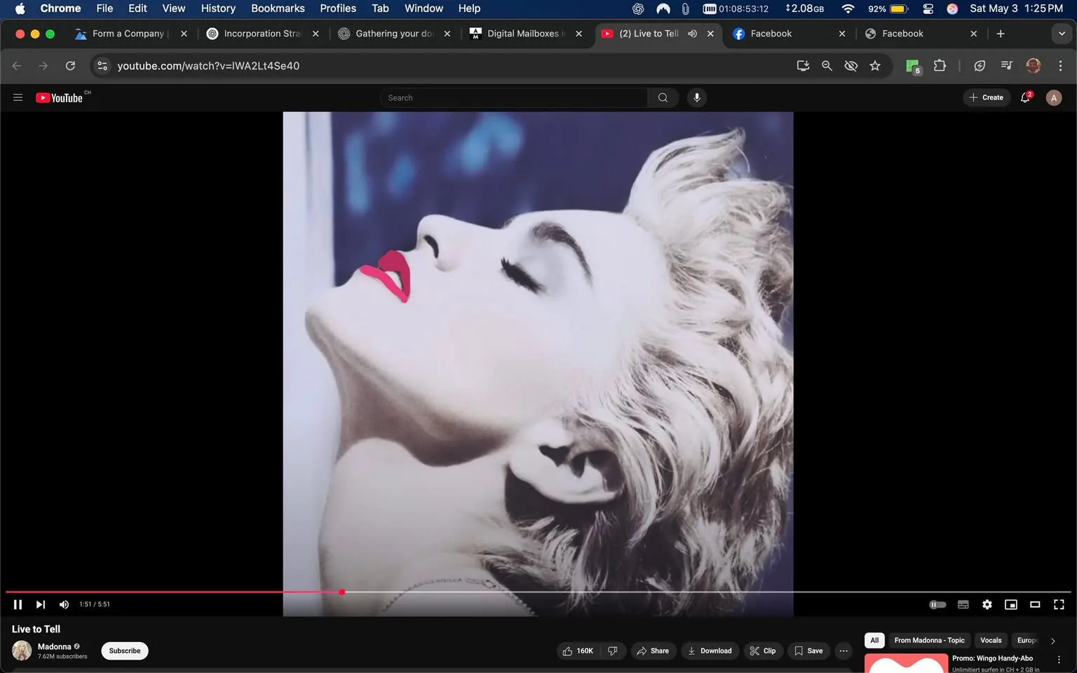 The image displays a close-up of a woman's profile, characterized by a striking pose. The woman has light, wavy hair styled in a voluminous manner, with some strands falling gracefully. Her skin appears pale, and she has a strong jawline. The focus is on her face, which is turned slightly upward, suggesting a moment of contemplation or serenity.

Her lips are painted a bold red, contrasting sharply with her fair complexion. The makeup is minimal aside from the vibrant lipstick, allowing her natural features to stand out. Her eyes are closed, and her expression is serene, contributing to the overall aesthetic of the image.

The background is blurred, featuring soft blue tones that suggest a dreamy or ethereal quality. There are no distinct objects or text in the background, allowing the focus to remain solely on the woman's profile.

The image appears to be part of a video, as indicated by the YouTube interface at the bottom. The video is titled "Live to Tell," and the channel name displayed is "Madonna," along with a subscriber count of 7.63 million. The video progress bar indicates that it is currently at 1 minute and 51 seconds out of a total of 5 minutes and 51 seconds.

Overall, the image captures a moment that emphasizes beauty and elegance, framed within the context of a music video.