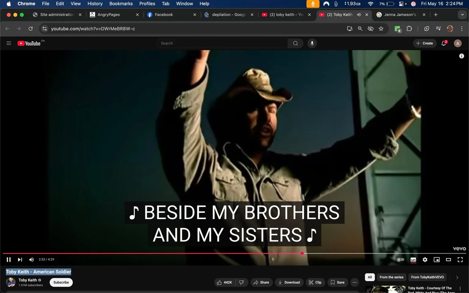 The image depicts a scene from a YouTube video titled "American Soldier" by Toby Keith. The video is currently playing, with a timestamp showing 2:53 out of a total duration of 4:29. 

**Readable Text:**
- The video features on-screen lyrics that read: "BESIDE MY BROTHERS AND MY SISTERS," presented in large, bold, white font against a dark background. 
- Below the video, the channel name "Toby Keith" is displayed, along with a subscriber count of 1.31 million. 
- There are also buttons for "Subscribe," "Share," "Download," and "Clip" visible in the lower part of the screen.

**Visible Brands and Logos:**
- The YouTube logo is present in the top left corner of the video player.
- The video is hosted on the "TobyKeithVEVO" channel, indicated by the channel name.

**Person's Appearance and Clothing:**
- A male figure is prominently featured in the foreground, with his arms raised. He appears to be singing or expressing enthusiasm.
- He is wearing a light-colored, button-up shirt with long sleeves, which is slightly wrinkled. The shirt has two breast pockets.
- On his head, he wears a tan cowboy hat, which has a slightly worn appearance.
- His facial expression is focused, and he appears to be engaged in the performance, though specific emotions cannot be inferred.

**Setting and Background:**
- The background is dark, suggesting an indoor or low-light environment, possibly a stage or performance area.
- There are hints of a structure behind him, possibly a wall or a backdrop, but details are minimal due to the lighting.
- The overall atmosphere appears to be that of a musical performance, likely aimed at an audience.

This description captures the observable details in the image without speculation or interpretation, focusing solely on factual elements.