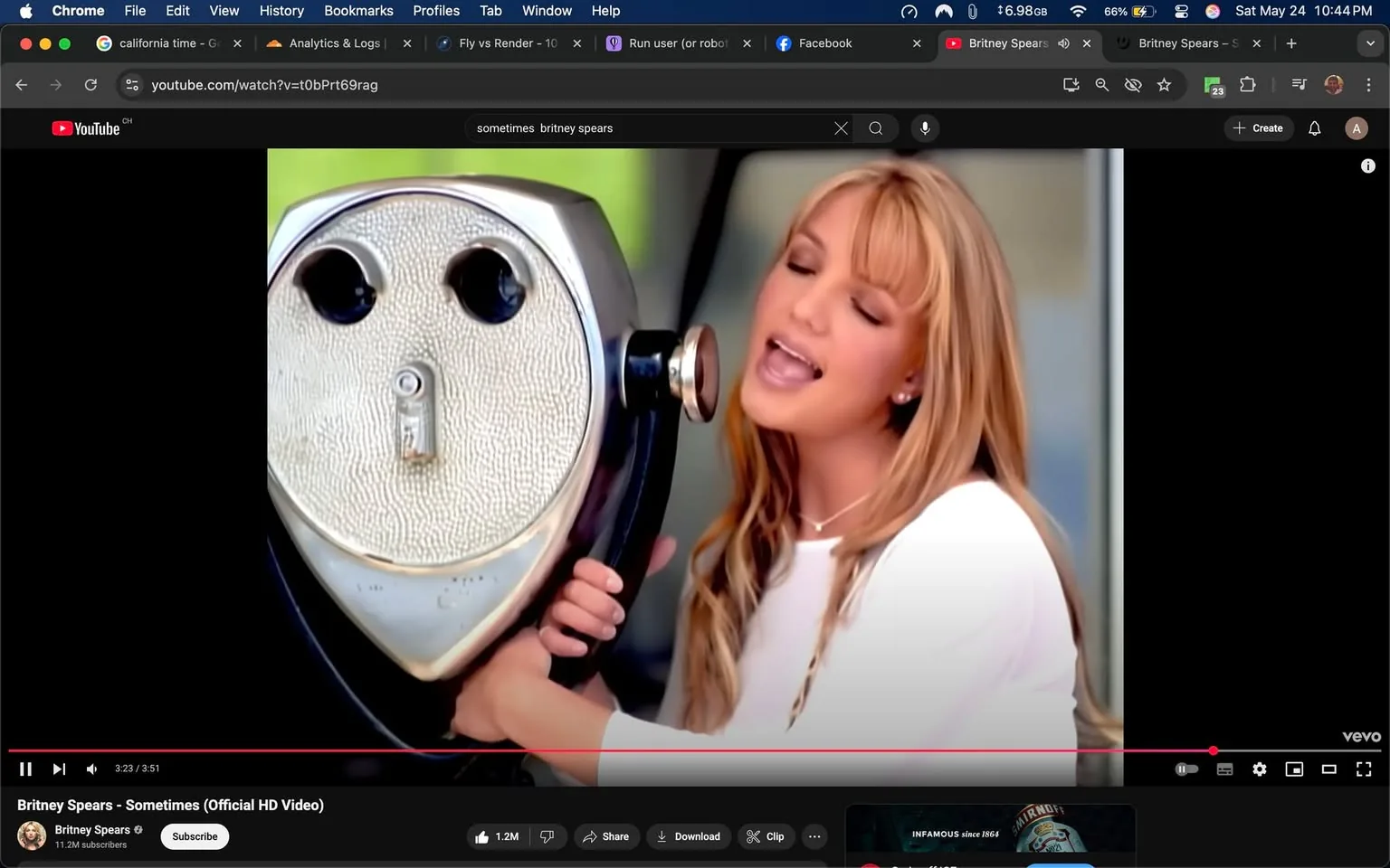 The image appears to be a still from a music video featuring a female singer with long, straight blonde hair, styled with soft waves. She is wearing a white top and is positioned slightly to the right of the frame, singing into a vintage-style coin-operated binocular viewer, which has a rounded, metallic body. The viewer has two circular lenses that resemble eyes, giving it a face-like appearance. The singer is holding the viewer with her left hand while her right hand is placed on the side of the viewer.

The background is blurred, suggesting an outdoor setting, possibly a park or a scenic area, with soft green hues visible, indicating foliage or grass. The lighting is bright, contributing to a cheerful ambiance. The singer's expression appears joyful and engaged, with her eyes closed and mouth open as if she is singing passionately.

In the lower part of the image, there is a YouTube interface visible, indicating that this is a video playback. The video title "Britney Spears - Sometimes (Official HD Video)" is displayed prominently, along with a play bar showing the current playback time at 3:23 out of a total of 3:51. Below the video, there are options to subscribe, share, and download, along with a subscriber count of 11.2 million for the channel. 

No other text, logos, or identifiable brands are present in the image aside from the YouTube branding. The overall composition focuses on the singer and the viewer, creating a visually engaging moment from the music video.