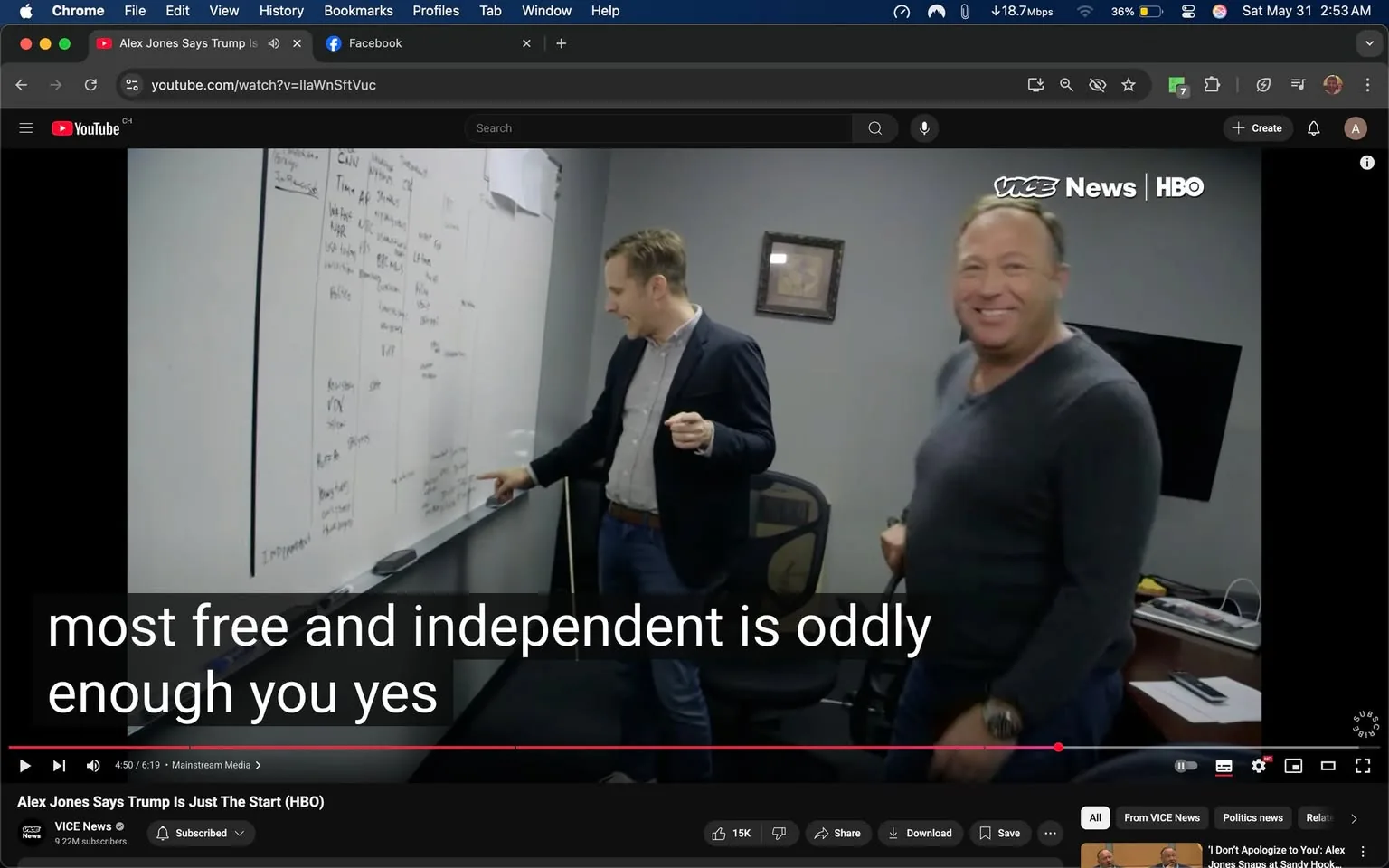 The image depicts a scene inside an office environment. In the foreground, two men are present. The man on the left is pointing at a whiteboard, while the man on the right is smiling and looking towards the camera. 

**Details of the individuals:**
- The man on the left is wearing a dark blazer over a light-colored shirt, with a belt that appears to be brown. He has short, light-colored hair and is gesturing with his right hand towards the whiteboard.
- The man on the right has a more casual appearance, wearing a gray long-sleeve shirt. He has short hair and a noticeable smile, suggesting a friendly demeanor.

**Whiteboard Content:**
The whiteboard is filled with handwritten notes and diagrams. The text appears to be organized into columns and rows, with various media outlets and possibly categories listed. Some of the visible words include "CNN," "MSNBC," "Fox," and "Politico," indicating a discussion related to media or news. There are also other terms and phrases that are not fully legible due to the angle of the image.

**Setting:**
The background features a gray wall, and there is a framed picture hanging on the wall behind the men. To the right, there is a black screen or monitor, and a desk with some items on it, although the details of those items are not clearly visible. The office appears to be well-lit and organized, with a chair visible in the background.

**Text Overlay:**
At the bottom of the image, there is a subtitle that reads, "most free and independent is oddly enough you yes," indicating that the conversation may be related to media independence or freedom.

Overall, the scene captures a moment of discussion in a professional setting, with a focus on media-related topics as indicated by the content on the whiteboard.