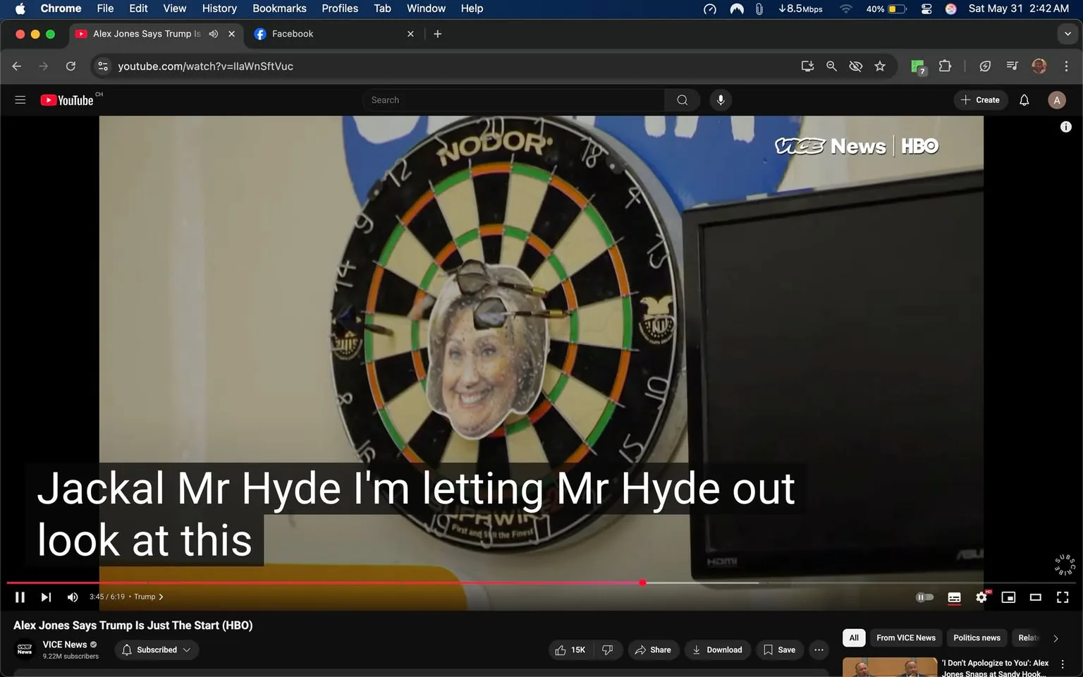 The image features a dartboard mounted on a wall, with a colorful arrangement of black, green, and orange segments. At the center of the dartboard, there is a cutout of a smiling face, which appears to be a humorous representation of a public figure, adorned with sunglasses. The dartboard is labeled with the brand name "NODOR," which is visible at the top. 

To the right of the dartboard, there is a black television screen that is turned off, with a visible HDMI port on its side. The background is a light-colored wall, possibly beige or off-white, which contrasts with the dartboard's vibrant colors. Above the dartboard, there is a blue area that seems to have some text or logo, but the details are not clearly visible.

In the foreground, there are subtitles displayed at the bottom of the image, which read: "Jackal Mr Hyde I'm letting Mr Hyde out look at this." The text is in a bold, white font against a dark background, indicating that it is part of a video or broadcast.

Overall, the setting appears to be a casual indoor environment, possibly a recreational space or a studio, where the dartboard serves as a focal point for humor or commentary. The elements present suggest a lighthearted or satirical context, likely related to a discussion or presentation involving the dartboard's imagery.