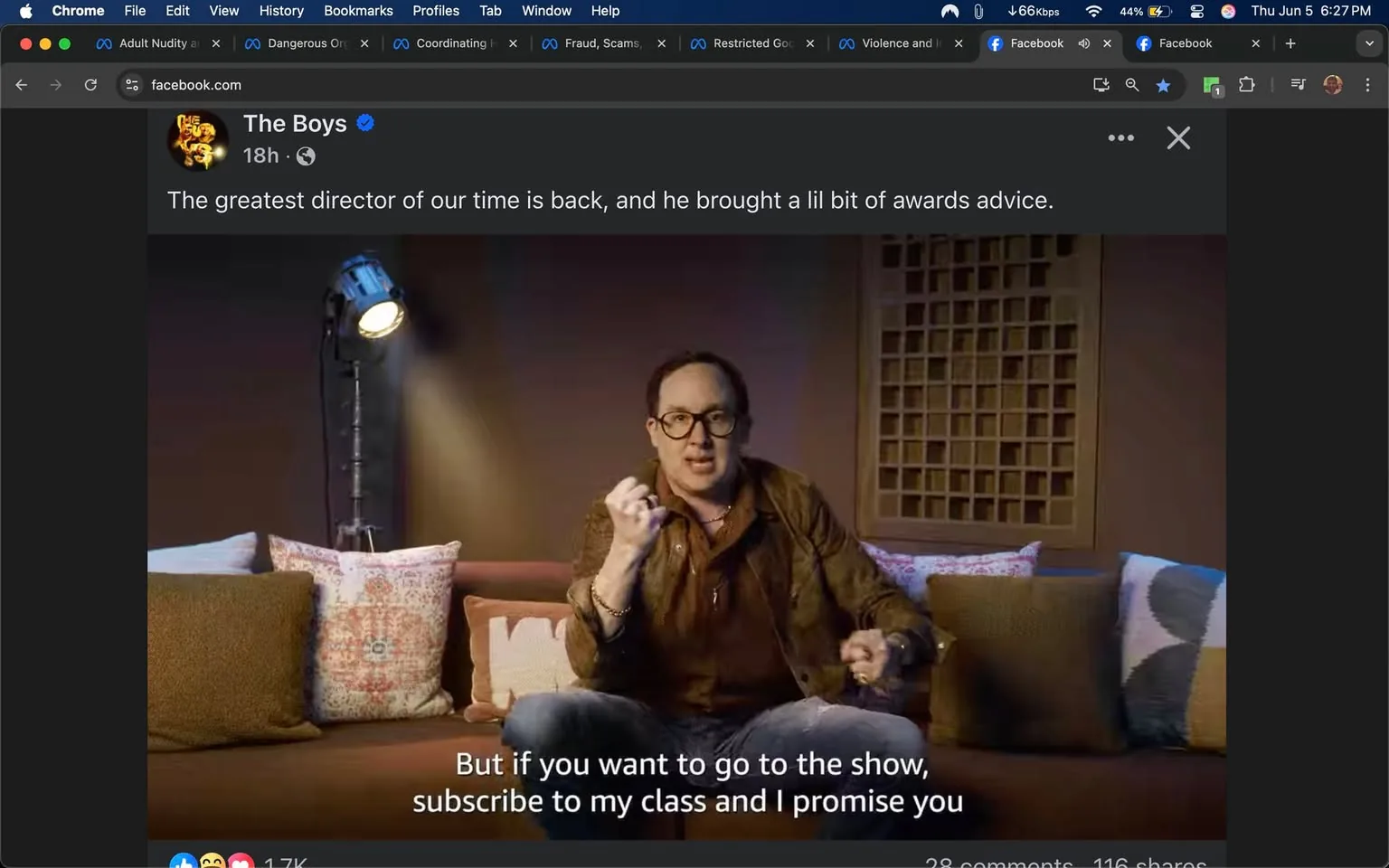 The image features a man sitting on a couch in a well-lit indoor setting. He is wearing a brown leather jacket over a dark shirt, with blue jeans. The man has short, dark hair and is wearing glasses. He appears animated, using his hands to emphasize his points while speaking. His facial expression is engaged and expressive.

The couch is adorned with several decorative pillows in various colors and patterns. There are two prominent pillows: one has a geometric design in shades of red and white, while another is a solid brown. The couch itself is a muted color, possibly beige or light brown.

To the left of the man, there is a spotlight on a stand, casting light on him. The background features a wooden panel with a grid-like design, adding texture to the setting. The overall ambiance is cozy and informal, suggesting a casual talk or presentation.

At the bottom of the image, there is readable text that states: "But if you want to go to the show, subscribe to my class and I promise you." Above this text, there is a logo for "The Boys," which appears to be a stylized representation, possibly indicating a connection to a show or series.

The post is from a Facebook page, as indicated by the interface elements visible at the top of the image, including icons for reactions, comments, and shares. The post was made 18 hours ago, as noted in the timestamp. The engagement metrics show 1.7K reactions, 28 comments, and 116 shares. 

Overall, the image captures a moment of a presentation or promotional content related to "The Boys," with a focus on the speaker's advice regarding a class or show.