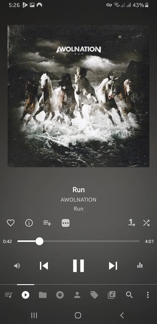 The image displays a music player interface featuring the song "Run" by AWOLNATION. The album cover is prominently displayed, showcasing a dramatic scene with several horses galloping through turbulent water. The horses are depicted in various colors, including white and brown, and are splashing through the waves, creating a sense of motion and energy. The background is dark and stormy, with clouds that suggest an ominous atmosphere.

At the top of the album cover, the band name "AWOLNATION" is written in bold, white capital letters. Below it, the title "RUN" is also displayed in a similar font style. The overall color scheme of the album cover is dark, with shades of black, gray, and white dominating the image, contributing to a dramatic and intense visual effect.

Below the album cover, the music player interface shows the song title "Run" and the artist "AWOLNATION" in a clear, white font. The playback progress bar indicates that the song is currently at 42 seconds, with a total duration of 4 minutes and 1 second. There are various playback controls visible, including play, pause, and skip buttons, as well as options for adding the song to a playlist or sharing it.

The device's status bar at the top indicates the time (5:26), battery level (43%), and signal strength, suggesting that this is a mobile device displaying the music player interface. The overall layout is clean and user-friendly, focusing on the music experience.
