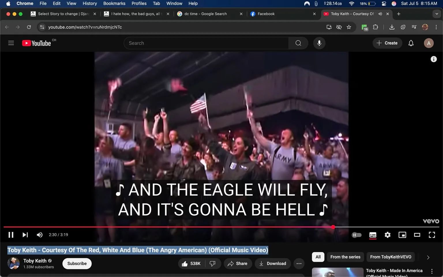 In the image, a lively crowd is gathered, likely at a concert or event. Many individuals are wearing military-style clothing, and some are waving small American flags, indicating a patriotic atmosphere. The expressions on their faces show excitement and enthusiasm, with several people raising their arms in celebration. 

The lyrics displayed on the screen read, "AND THE EAGLE WILL FLY, AND IT'S GONNA BE HELL," suggesting a powerful and possibly aggressive sentiment in the context of the song. The overall mood is energetic and spirited, with the crowd's engagement highlighting a sense of unity and pride.

The setting appears to be under a large tent or canopy, which adds to the communal feel of the gathering. The lighting is somewhat dim, but the excitement of the crowd stands out vividly against the backdrop. This scene conveys a strong emotional connection to themes of patriotism and camaraderie.