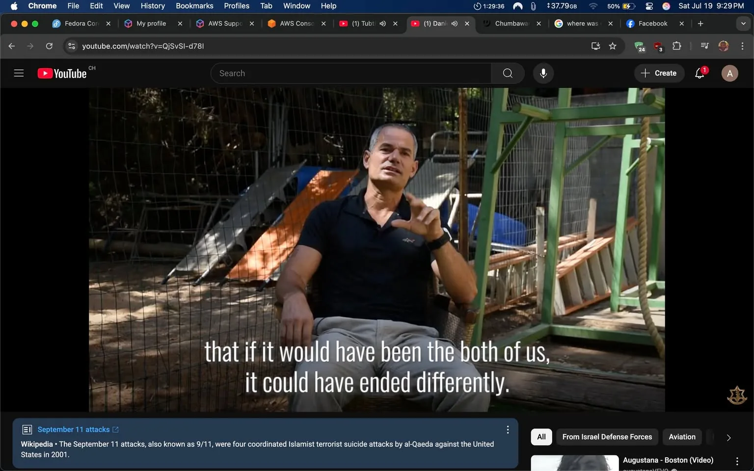 The image shows a man sitting on a chair outdoors, gesturing with his right hand while speaking. He has short, dark hair and is wearing a black polo shirt. The background features a fenced area with some wooden structures, possibly a playground or animal enclosure, indicating a casual or informal setting. 

Text overlays the image, stating, "that if it would have been the both of us, it could have ended differently," suggesting a reflective or serious tone. The man's expression appears earnest, possibly conveying a sense of regret or contemplation. 

There are no recognizable public figures in the image, and no explicit logos or branding are visible. The context hints at a discussion related to significant events, possibly touching on sensitive topics like the September 11 attacks, as indicated by the text below the video player. The overall tone seems serious, with an emphasis on personal reflection or a pivotal moment in a narrative.