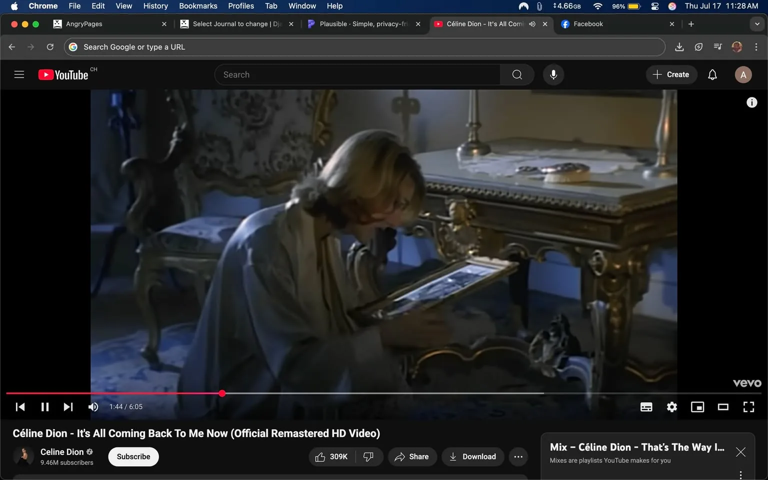 The image shows a scene from the music video for "It's All Coming Back to Me Now" by Celine Dion. In the foreground, a woman with shoulder-length, wavy blonde hair is kneeling beside an ornate, gold-accented table. She is wearing a light-colored robe and appears to be examining a framed picture closely, suggesting a moment of introspection or nostalgia. Her facial expression conveys deep emotion, possibly sadness or longing.

The background features lavish decor, including intricate wallpaper and a plush chair, enhancing the opulent atmosphere. A few items are scattered on the table, including a candle holder and a piece of paper, which may symbolize memories or past experiences. The lighting is soft and moody, contributing to the overall emotional tone of the scene.

The branding visible is the YouTube logo, indicating the platform where the video is hosted. The video's title and artist name are displayed prominently, emphasizing its commercial nature. There are no explicit or controversial elements in this image. The tone is reflective, capturing a moment of emotional depth in the narrative of the song.