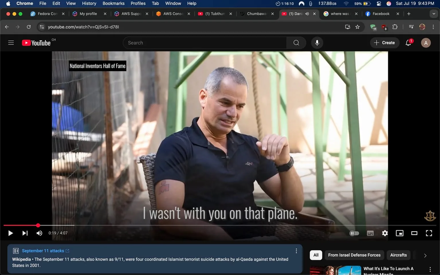 The image captures a moment from a video, likely an interview or a personal recounting, set in a casual outdoor environment. The subject, a man with short, silver hair and a fit build, is seated on a wicker chair. He wears a black polo shirt, which fits snugly, suggesting a relaxed yet attentive demeanor. His expression is serious and contemplative, as he gestures with one hand, possibly emphasizing a point in the conversation.

In the background, there are hints of a rustic setting, with green metal structures that appear to be part of a larger framework, perhaps a garden or patio area. The lighting is warm and natural, indicating that it might be daytime. The blurred background suggests a bit of depth, focusing attention on the man while still providing context to the environment.

The text overlay reads, "I wasn't with you on that plane," which adds a layer of intrigue and emotion to the scene. This statement hints at a significant and possibly somber topic being discussed, likely related to personal experiences or historical events. The tone of the conversation seems serious, and the man's expression reflects a mix of sincerity and perhaps regret.

The branding at the top left corner indicates that this video is associated with the "National Inventors Hall of Fame," suggesting that the subject may have a background in innovation or invention, or that the discussion might touch on themes of creativity and resilience in the face of adversity.

Overall, the image conveys a moment of reflection, with the man seemingly engaged in a meaningful dialogue that resonates with themes of loss, memory, and perhaps the impact of significant events on personal lives. The combination of his serious demeanor, the poignant statement, and the inviting yet rustic setting creates a compelling visual narrative that invites viewers to ponder the deeper implications of the conversation.