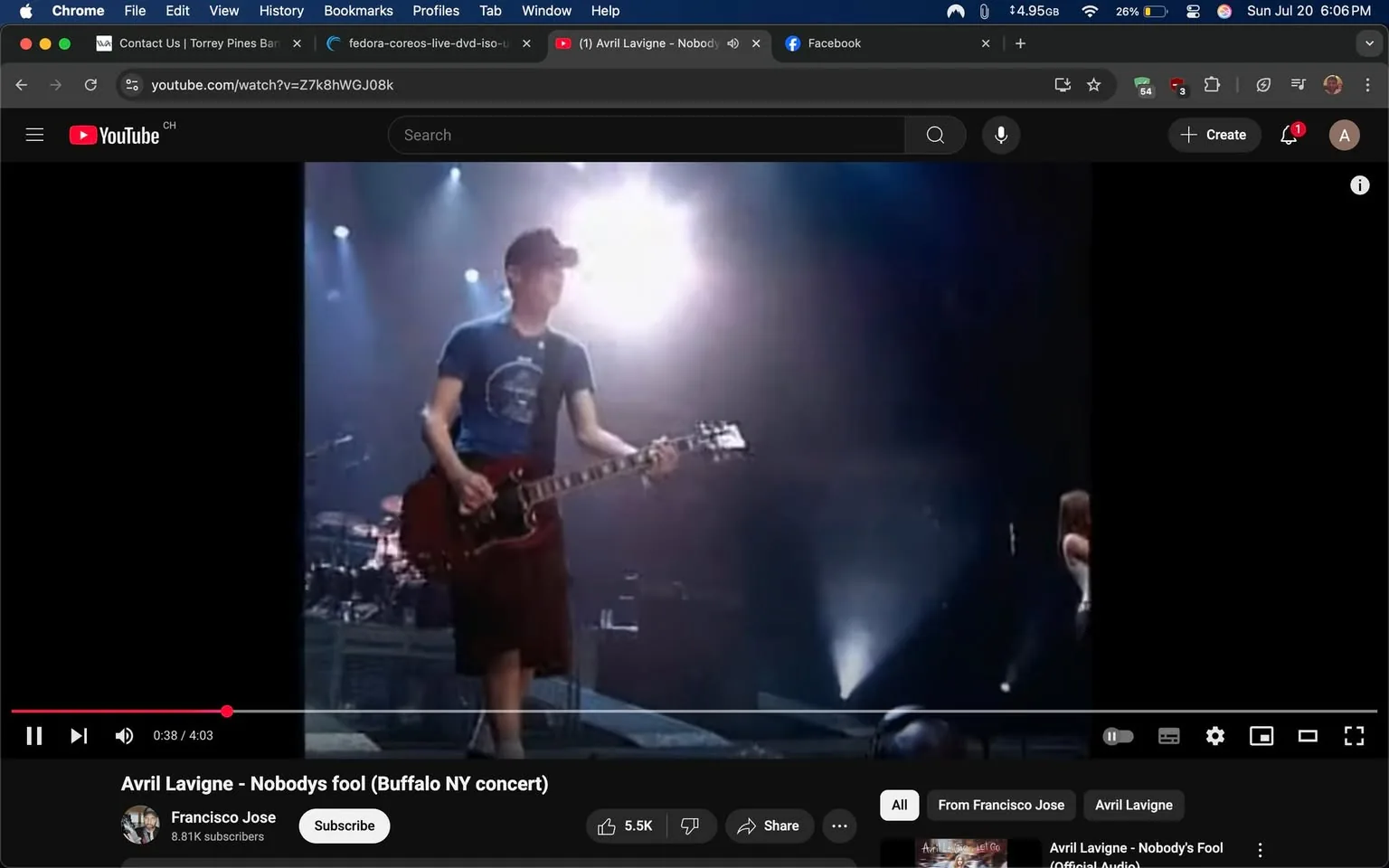 The image captures a moment from a live concert performance, specifically from Avril Lavigne's song "Nobody's Fool," during a show in Buffalo, NY. The scene is illuminated by dramatic stage lighting, creating a vibrant atmosphere typical of a rock concert.

In the foreground, a male guitarist stands confidently, gripping his electric guitar. He wears a fitted blue t-shirt adorned with a circular graphic, paired with dark shorts that give him a casual yet cool appearance. His stance suggests he is fully engaged in the performance, possibly lost in the music as he plays. The lighting casts a bright glow around him, enhancing the energy of the moment and highlighting his focused expression.

Behind him, the stage is set with various instruments and equipment, hinting at the collaborative nature of the performance. The background features soft blue and white lights, creating a dynamic visual contrast that adds depth to the scene. The audience is likely captivated, although they are not visible in this frame.

The overall tone of the image is energetic and lively, reflecting the excitement of a live music experience. The guitarist's expression and posture convey a sense of passion and dedication to the performance, which is a hallmark of live rock concerts. The lighting and stage setup contribute to an atmosphere filled with anticipation and enthusiasm, typical of Avril Lavigne's concerts, where fans often sing along and immerse themselves in the music.

This snapshot encapsulates the essence of live music, where artists and audiences connect through the shared experience of performance, emotion, and sound. The image serves as a reminder of the power of music to bring people together, creating memorable moments that resonate long after the concert ends.