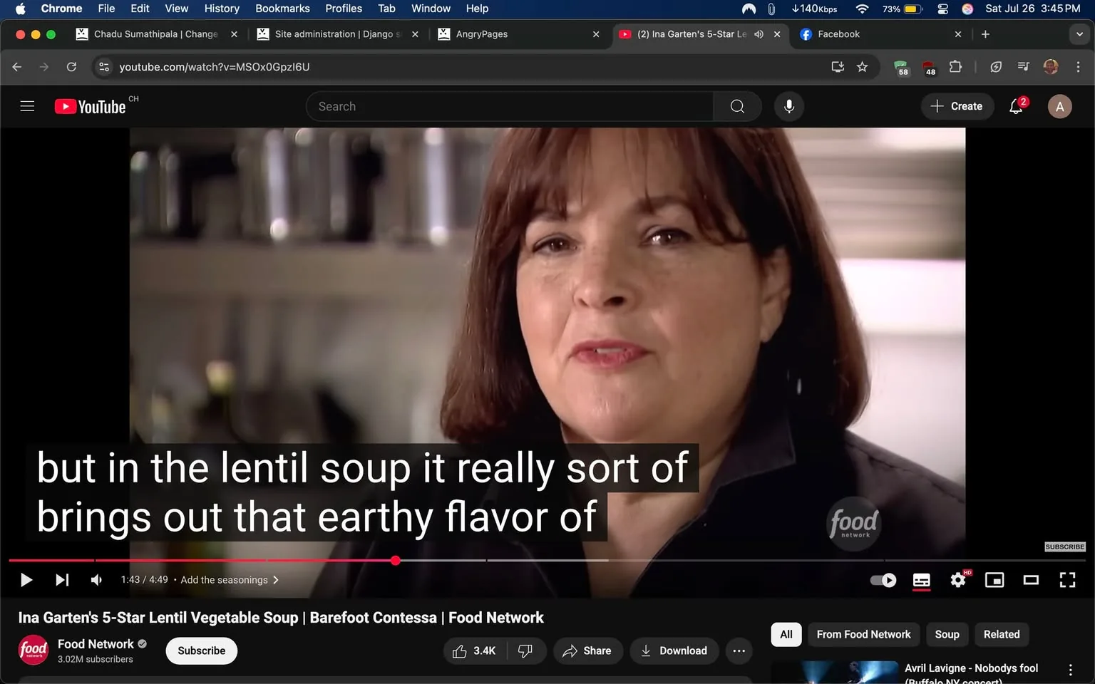 The image captures a moment from a cooking show, likely featuring a well-known chef or culinary personality. The focus is on a woman with shoulder-length, dark brown hair that has soft waves. She has a warm expression, suggesting she is engaged in a thoughtful discussion about food. Her makeup is subtle, enhancing her features without being overpowering, and she wears a black shirt that adds to her professional yet approachable appearance.

In the background, there are blurred kitchen elements, including metallic containers and possibly some cooking utensils, indicating that the setting is a kitchen. The atmosphere feels cozy and inviting, typical of a cooking show where the host shares personal insights and tips about preparing meals.

The subtitles visible on the screen suggest that she is discussing a lentil soup, emphasizing its "earthy flavor." This choice of words evokes a sense of comfort and warmth associated with homemade meals, hinting at the soup's wholesome ingredients. The mention of "earthy flavor" also suggests a connection to nature and the simplicity of using fresh, natural ingredients.

The branding in the corner indicates that this is a segment from the Food Network, a channel known for its culinary programming. The presence of the Food Network logo adds a layer of credibility to the content, as viewers might recognize it as a trusted source for cooking inspiration and recipes.

Overall, the image conveys a sense of passion for cooking and the joy of sharing culinary knowledge. The woman's expression and the context of her discussion invite viewers to appreciate the nuances of flavor and the art of cooking, making it relatable and engaging for anyone interested in food.