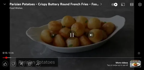 This image is a video frame from a YouTube video titled "Parisian Potatoes – Crispy Buttery Round French Fries" by the channel "Food Wishes." The frame shows a close-up of a white dish filled with perfectly round, golden-brown potatoes, likely prepared in a buttery and crispy style. The potatoes are neatly arranged in an elegant white serving dish, emphasizing a gourmet presentation. The background features a muted gray surface, which contrasts with the golden hue of the potatoes, making them pop visually. The lighting is soft and highlights the glossy texture of the potatoes, indicating they are freshly prepared and appetizing. There are green garnishes visible, adding a touch of color and suggesting freshness. The video appears to be part of a cooking tutorial or recipe presentation.
- Title: "Parisian Potatoes – Crispy Buttery Round French Fries"
- Channel / profile: "Food Wishes"
- Site / app: "YouTube"