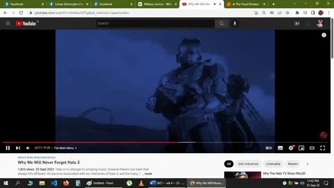 The image is a screenshot from a YouTube video titled "Why We Will Never Forget Halo 3," hosted on the channel "LaperLarden." It shows a sci-fi scene with a character in futuristic armor, likely from the Halo series, set against a dark, nighttime background. The scene is blue-tinted, emphasizing a dramatic and somber mood. The armored figure appears prepared for battle, holding a weapon, with a hillside or landscape stretching behind them. The setting gives a sense of vastness and impending action typical of the Halo universe. The video timestamp indicates it's around 6:17 minutes into the video, and the video discusses the memorable aspects of the game Halo 3, as suggested by the title and tags like "halo3," "halo," and "halo3anniversary." The screenshot shows the interface of YouTube, with visible elements like the video progress bar, view count, and upload date.