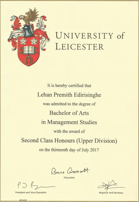 The image shows an official degree certificate from the University of Leicester. It certifies that Lehan Premith Edirisinghe was awarded a Bachelor of Arts in Management Studies with Second Class Honours (Upper Division) on July 13, 2017. The certificate features the university's crest prominently on the left side, which includes a shield with decorative elements and a mythical creature. The text is elegantly formatted, primarily using serif fonts, which lend a formal and official appearance to the document.
Signatures of the Chancellor, President and Vice-Chancellor, and the Registrar and Secretary are visible at the bottom, indicating authenticity. The document number "387439" is printed at the bottom left, which might be used for identification or record-keeping purposes. The certificate is designed on a light, neutral background, which enhances readability and highlights the text and crest. This type of document is typically stored in a portfolio or frame for display, reflecting academic achievement and recognition.