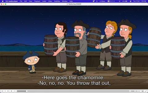 This image is a screenshot from the animated TV show "Family Guy," specifically from season 22, episode 1. The scene takes place at night on a wooden dock by the sea. In the foreground, the character Stewie, recognizable by his distinctive football-shaped head and sophisticated attire, is dressed in historical colonial garb, complete with a tricorn hat. He stands to the left, looking at a group of men who are dressed similarly, each holding a wooden barrel. The men are aligned in a line, exchanging glances and expressions of concern or confusion. The barrels they carry suggest a historical setting, possibly referencing a famous event like the Boston Tea Party.
The lighting is dim, consistent with nighttime, and the sky is filled with stars. The mood is comedic, underscored by the humorous subtitles where Stewie is instructing the men about what to throw out. The animation style is typical of "Family Guy," with bold outlines and vibrant colors. The text overlay from the VLC media player interface is visible at the top, indicating the show's title and episode.