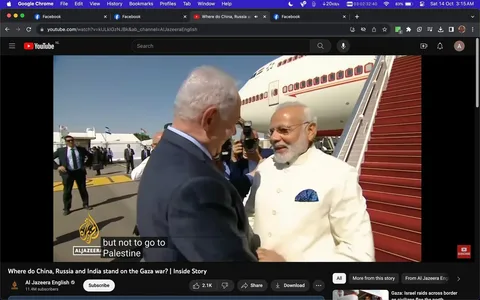 1) In this screenshot, Benyamin Netanyahu and Modi are seen greeting each other warmly at an airport setting, indicated by the aircraft and red-carpeted stairs in the background. Modi is dressed in a cream-colored traditional outfit with a blue pocket square, exuding a formal and diplomatic ambiance. Netanyahu, visible from the back, is clad in a dark suit. The setting is outdoors, with clear skies, suggesting a formal arrival or departure. Behind them, several people are present, including security personnel and photographers capturing the moment. The scene conveys a sense of cordiality and official engagement, likely part of a state visit or diplomatic meeting. The video is from the Al Jazeera English YouTube channel, with a title discussing the geopolitical stances of China, Russia, and India. Captions on the video mention the topic of Palestine.
2) On-screen text block:
- Title: "Where do China, Russia and India stand on the Gaza war? | Inside Story"
- Channel / profile: "Al Jazeera English"
- Site / app: "YouTube"
- Captions / subtitles: "but not to go to Palestine"