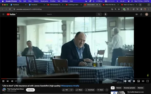 James Gandolfini is seated at a table in a restaurant setting for a life insurance ad. The scene is indoors with natural light streaming in through large windows, creating a soft ambiance. James Gandolfini is wearing a dark jacket over a light blue shirt, and he has a thoughtful expression, perhaps suggesting reflective or serious themes typical of a life insurance advertisement. The table has a checkered tablecloth, and there are various condiments placed on it, contributing to the casual dining atmosphere. In the background, other patrons and a server can be seen, adding a sense of normalcy and everyday life to the scene. The colors are muted, enhancing the reflective mood of the ad. The video is a high-quality production with clear emphasis on Gandolfini, suggesting his importance in the ad's messaging.
- Title: "\"Life is short\" a life insurance ad with James Gandolfini (high quality) #thesopranos #mafia"
- Channel / profile: "That Fuzzing Rock Show"
- Site / app: "YouTube"