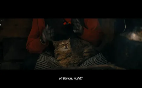 The image depicts a cozy indoor scene with a cat resting contentedly on a person's lap. The person is wearing a red jacket and striped pants, and their hands are gloved. The scene is warmly lit, creating a comfortable and intimate atmosphere. The cat appears relaxed, with its eyes partially closed, suggesting contentment. The person’s face is not visible, focusing attention on the cat and the overall mood. The background is dim, enhancing the cozy feel. The lighting and composition suggest a quiet, peaceful moment, possibly by a fireplace or in a rustic setting. The subtitle reads, “all things, right?” indicating a conversational tone in the context of the scene.