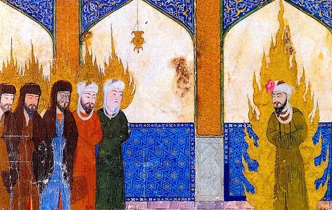 This image is a detailed illustration of Islamic art, featuring a group of men inside a building with ornate decor. The setting includes intricate blue tilework and arches adorned with rich patterns. The men are dressed in traditional attire, with turbans and robes, and some have halos of fire around their heads, indicating spiritual or holy significance. One figure stands apart with a larger halo, suggesting a prominent position or role. The colors are vibrant, especially the blues and golds, which are typical in Islamic art. The use of fire as a motif adds a mystical and divine element. The medium appears to be a traditional painting or manuscript illustration, capturing a historical or religious scene with symbolic elements.