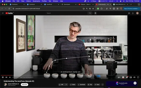 The image is a screenshot from a YouTube video titled "Understanding The AeroPress (Episode #2)" on the channel of James Hoffmann. The scene is set indoors in a kitchen with a focus on coffee brewing. James Hoffmann is standing behind a counter, where several coffee cups are neatly lined up. He is wearing glasses and a dark, patterned sweater. The background features a white tiled wall with various coffee machines and equipment, suggesting a setting dedicated to coffee preparation. On the left, colorful framed artwork adorns the wall. The lighting is bright, highlighting the details of the coffee cups and the graph displayed on the screen, which appears to be part of a discussion about coffee extraction. The subtitle "in extraction early on" suggests a detailed explanation of the brewing process. The interface shows typical YouTube elements like the play button, video progress bar, and viewer engagement metrics. The overall mood is educational and focused on coffee expertise.
- Title: "Understanding The AeroPress (Episode #2)"
- Channel / profile: "James Hoffmann"
- Site / app: "YouTube"
- Captions / subtitles: "in extraction early on"