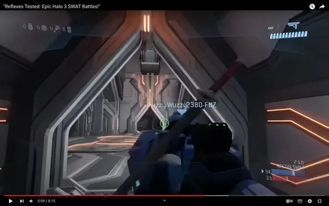 This screenshot appears to be from a gaming video titled "Reflexes Tested: Epic Halo 3 SWAT Battles!" It captures a scene within a game, specifically Halo 3, where the player is navigating through a futuristic corridor. The environment is sleek and metallic, with angular architecture and glowing orange accents that illuminate the path. The perspective is first-person, showing the player holding a weapon.
On-screen information includes a player name, "Fuzzy Wuzzy2380-FUZ," in bright lettering, indicating a teammate or opponent within the game. Other HUD elements show a score of 34 to 23 along with the game mode “RECON SWAT,” suggesting a competitive match with the clock displaying 7:10 remaining. The minimalistic design and focus on the weapon suggest a tactical, action-oriented segment typical of the SWAT game type. The lighting in the scene is dynamic, casting shadows and creating a high-tech, immersive atmosphere common in sci-fi-themed games.