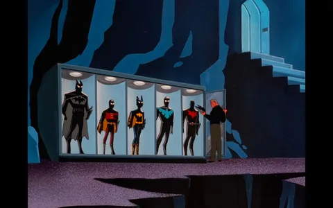 The image depicts a scene from "Batman Beyond." It shows a character standing in a cavernous space, possibly the Batcave, in front of a display case featuring several superhero costumes. The setting has a dark, rocky environment, typical of the Batcave's design. The display case is well-lit and showcases various suits associated with the Batman legacy. The costumes include a classic Batman suit, a Robin suit, and others with distinct designs and colors, like a blue and black Nightwing suit and the red-black suit of Batman Beyond.
The man is positioned near the end of the display, examining or possibly selecting a piece of equipment. The suits are housed in individual compartments, each illuminated from above, highlighting their intricate details. The lighting in the cave is minimal, with the case being the primary source of light, casting shadows and enhancing the mysterious atmosphere. The overall art style is consistent with animated series aesthetics, using bold lines and flat colors to define characters and environments.