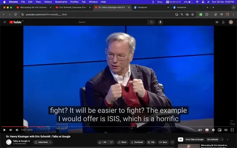 1) Rich description: The image is a video frame from an interview titled "Dr. Henry Kissinger with Eric Schmidt | Talks at Google," hosted on YouTube by the channel "Talks at Google." Eric Schmidt is visible in the frame, seated on a chair and appearing engaged in conversation. He is gesturing with both hands, suggesting an animated discussion. Eric Schmidt is wearing glasses, a white shirt, a red sweater, and a dark blazer, giving him a formal yet approachable appearance. The background features a blue screen, adding a professional ambiance to the setting. Bright studio lighting illuminates the scene, focusing on Eric Schmidt. The video player interface shows the playhead at 12:34 of a 1:06:25 duration, with visible options like play, volume, and full-screen. Subtitles at the bottom read, "fight? It will be easier to fight? The example I would offer is ISIS, which is a horrific," indicating a serious topic of discussion.
2) On-screen text block:
- Title: "Dr. Henry Kissinger with Eric Schmidt | Talks at Google"
- Channel / profile: "Talks at Google"
- Site / app: "YouTube"
- Captions / subtitles: "fight? It will be easier to fight? The example I would offer is ISIS, which is a horrific"