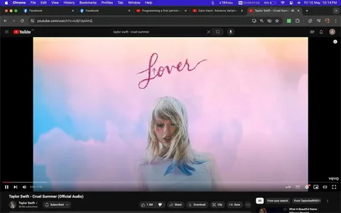 The screenshot captures a YouTube video page featuring the official audio for "Cruel Summer" by Taylor Swift. The visual displays pastel-colored clouds in the background, primarily in shades of pink and blue, creating a dreamy atmosphere. In the forefront, there is an image of a woman with long, blonde hair and blue accents at the tips. She is wearing a white shirt and has a calm and serene expression. The word "Lover" is written in a glittery, pink script above her, indicating the album title. The YouTube interface shows the video's progression bar at the bottom, with visible buttons for play, volume, and other controls. The title of the video, "Taylor Swift - Cruel Summer (Official Audio)," is displayed below, along with the channel name, "Taylor Swift." The screenshot includes typical YouTube features such as like, share, and download buttons, along with the subscriber count of 58.8M subscribers for the channel.