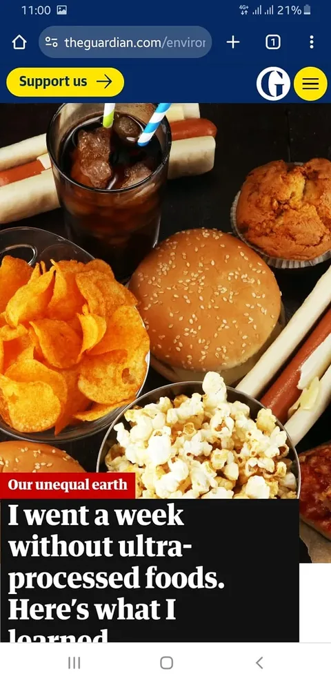 The image is a screenshot from The Guardian website featuring a headline, "I went a week without ultra-processed foods. Here’s what I learned." It shows a variety of foods typically considered ultra-processed, such as a burger with a sesame seed bun, a bowl of potato chips, popcorn, a muffin, and hot dogs with buns. Additionally, there's a glass of cola with straws visible. The arrangement suggests a focus on discussing dietary habits and the impact of processed foods. The article belongs to a section titled "Our unequal earth," indicating a broader theme of environmental and health-related discussions. The colors are bright and the setting appears to be indoors, emphasizing the variety of processed foods typically available. The Guardian logo is visible in the top right corner, and there's a "Support us" button in yellow below the site’s navigation bar.