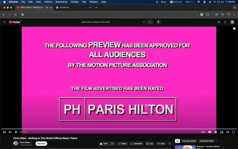 The screenshot captures part of a YouTube video titled "Paris Hilton - Nothing In This World (Official Music Video)" on the Paris Hilton channel. The image shows a vibrant pink background with white and black text typical of a movie preview screen, stating, "THE FOLLOWING PREVIEW HAS BEEN APPROVED FOR ALL AUDIENCES BY THE MOTION PICTURE ASSOCIATION." Below, it notes the film is rated with a stylized logo reading "PH PARIS HILTON." This screen mimics the format used in movie trailers to indicate age-appropriate content. The YouTube interface elements such as the video title, subscriber count, and control buttons are visible at the bottom, indicating that the user is viewing this video in a browser window. The interface is familiar, with icons for liking, sharing, downloading, and saving the video. The scene is static, focusing on the preview text, which gives a promotional feel to the video, aligning with the music industry's common practice of using cinematic styles in music video presentations.