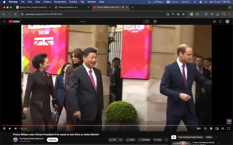 The image is a screenshot from a YouTube video titled "Prince William asks China's President if he wants to test drive an Aston Martin?" It features a formal setting outside a building, where several individuals are engaged in conversation. On the left, Xi Jinping is walking beside a woman, both dressed in formal attire. Xi Jinping is wearing a dark suit with a white shirt and a red tie, and he has a pleasant expression on his face. In the foreground on the right, a man in a dark suit, identified by the hint as William, is gesturing with his right hand, perhaps in conversation or directing attention. Behind them, banners with the words "GREAT BRITAIN" and the Union Jack flag are visible, adding a diplomatic and official tone to the scene. The presence of security and other attendees suggests this is a high-profile event. The lighting is natural, indicating daytime, and the mood appears cordial and formal.
- Title: "Prince William asks China's President if he wants to test drive an Aston Martin?"
- Channel / profile: "The Royal Family Channel"
- Site / app: "YouTube"