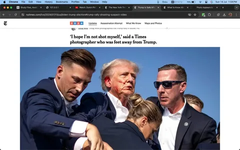 Donald Trump is depicted in a tense and dramatic scene, surrounded by security personnel, including Sean Curran, who is positioned on the right wearing sunglasses. The setting is outdoors with a clear blue sky, suggesting a daytime event. Donald Trump appears to have an injury on his face, with visible red marks, possibly simulating blood, which adds to the urgency and seriousness of the moment. The security team is actively assisting him, with one person supporting him from the left and another crouched before him, indicating heightened security measures and concern for his safety.
The individuals are dressed in formal attire, wearing dark suits and white shirts, which is typical for security personnel. The expressions on their faces suggest focus and concern, emphasizing the gravity of the situation. The image is captured with high clarity, typical of professional news coverage.
This screenshot is from a New York Times article, with the headline expressing a photographer’s concern during the event. The article is attributed to Doug Mills, a photographer for The New York Times. This visual and accompanying text suggest a narrative centered around an emergency or security incident involving Donald Trump.