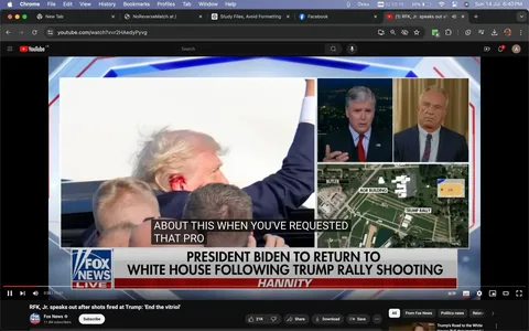 The image is a screenshot from a Fox News broadcast on YouTube titled "RFK, Jr. speaks out after shots fired at Trump: 'End the vitriol'." The screen is divided into several sections. On the left, there is a large image of Donald Trump raising his arm, with what appears to be a red mark on his head, surrounded by people. On the right, there is a split-screen with two smaller frames: one showing a news anchor speaking, and the other showing a guest who appears to be listening attentively. Below these, a map highlights a location marked as "TRUMP RALLY" with labels for "AGR BUILDING" and "BUTLER."
The bottom of the screen features an on-screen text banner reading, "PRESIDENT BIDEN TO RETURN TO WHITE HOUSE FOLLOWING TRUMP RALLY SHOOTING," indicating the context of the news. Also visible is the word "HANNITY," suggesting this is from Sean Hannity’s show on Fox News. The video title and channel are clearly from Fox News, emphasizing a political news topic involving Donald Trump and a recent incident at a rally. The setting is a typical news broadcast with a serious tone, reflecting on political events.