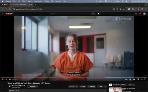 The video frame is from a YouTube video titled "Come to Jail With Us. You’ll Need a Calculator. | NYT Opinion," published by The New York Times. The scene is set indoors in what appears to be a prison environment. A person, wearing an orange prison uniform, sits in a corridor-like space with light-colored walls and large windows that let in natural light. The background shows a few chairs lined up along the wall and a closed door, suggesting a waiting or holding area.
The individual is centered in the frame, looking directly at the camera, conveying a sense of seriousness and engagement. The lighting is soft, highlighting the person's features and the vividness of the orange attire. The subtitle displayed reads, "I feel like they've set me up for failure," suggesting a discussion about personal experiences or systemic issues within the justice system.
This frame is part of an opinion piece, as indicated by the "NYT OPINION" text visible on the screen, reflecting the broader topic of the video. The composition and focus on the interviewee emphasize the personal and emotional nature of the content being discussed.