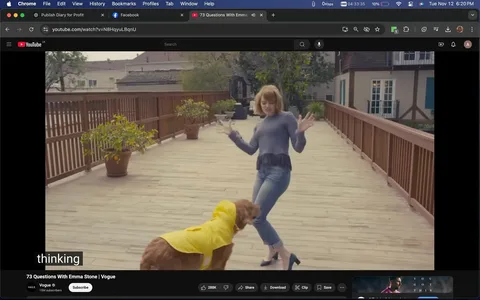 Emma Stone is seen dancing playfully with her pet dog on a wooden deck in this lively image. The setting is outdoors, featuring a spacious, sunlit deck lined with potted plants along a wooden railing. Emma Stone is dressed casually in a long-sleeved, textured grey top and blue jeans, paired with black heeled shoes. Her expression is animated and joyful as she interacts with her dog, who is wearing an adorable yellow raincoat. The moment captures a sense of fun and spontaneity, emphasizing a warm, personal interaction between Emma Stone and her pet.
The video title "73 Questions With Emma Stone | Vogue" is displayed prominently, indicating the context of a casual interview-style video by the Vogue channel on YouTube. The caption "thinking" is visible, possibly reflecting Emma Stone's playful contemplation or response to an off-screen question. This engaging scene offers a glimpse into the personal life of Emma Stone, blending a touch of glamour with everyday charm.
- Title: "73 Questions With Emma Stone | Vogue"
- Channel / profile: "Vogue"
- Site / app: "YouTube"
- Captions / subtitles: "thinking"