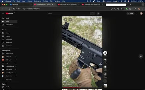 The image displays a close-up view of a firearm, specifically an HK 416, which is a type of assault rifle. The rifle is predominantly black and features a sleek design with a rail system on the top for mounting accessories. 

**Readable Text and Labels:**
- The firearm has visible text on the side, which reads "HK 416" along with "Cal. 5.56 mm" indicating the caliber of the weapon. 
- There is also a logo that appears to be a manufacturer’s mark, but it is not fully legible in this image.

**Visible Brands and Objects:**
- The firearm is branded as "HK," which stands for Heckler & Koch, a well-known manufacturer of firearms.
- The grip of the rifle is being held by a gloved hand. The glove is tan in color and appears to be tactical in nature, featuring a textured palm for grip.

**Setting and Background:**
- The background consists of a natural outdoor setting with a ground covered in small pebbles and patches of grass. The color palette is predominantly green and gray, suggesting a neutral outdoor environment.
- There are no identifiable structures or urban elements in the background, indicating that the scene is likely taking place in a rural or unpaved area.

**Clothing and Appearance:**
- The person holding the firearm is wearing tactical gloves that are tan and feature a textured grip. The hand is positioned in a way that suggests readiness or control of the weapon.
- No other parts of the person's clothing or appearance are visible, as the focus is primarily on the firearm and the gloved hand.

**Actions:**
- The individual appears to be holding the firearm in a stable manner, possibly preparing for use or demonstration. The posture suggests a level of familiarity with handling firearms.

Overall, the image captures a detailed view of the HK 416 rifle being held in an outdoor setting, with a focus on the firearm's features and the tactical gear of the individual.