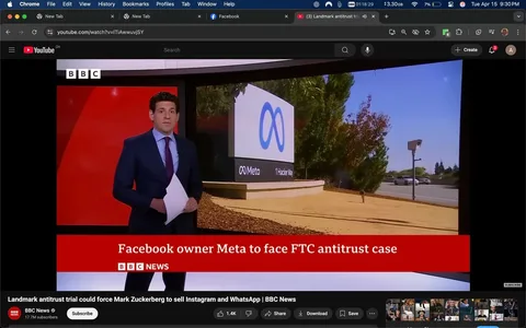 The image shows a news broadcast setup featuring a male news presenter standing in the foreground. He is dressed in a dark blue suit with a light blue dress shirt and a dark tie. The presenter is holding a stack of papers in his left hand and appears to be looking directly at the camera. His expression is neutral, and he is positioned in front of a large screen displaying a corporate logo.

The background features a prominent sign with the logo of Meta, which consists of a stylized blue infinity symbol. Below the logo, the text reads "Meta" and "1 Hacker Way," indicating the location associated with the company. The setting appears to be outdoors, with a clear blue sky and some greenery, including trees, visible in the background. There is also a road with a vehicle passing by, suggesting that the location is near a street or highway.

At the bottom of the screen, there is a red banner with white text that reads, "Facebook owner Meta to face FTC antitrust case." The text is accompanied by the BBC News logo in the top left corner, indicating the source of the broadcast. The overall composition suggests a news segment focused on a significant legal issue involving Meta, the parent company of Facebook.

The image is framed to emphasize both the presenter and the corporate logo, creating a professional news reporting atmosphere. The lighting appears bright, likely due to natural sunlight, enhancing visibility. The overall context indicates a serious news topic related to antitrust issues facing a major technology company.