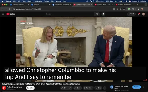 The image depicts a meeting taking place in a formal setting, likely an office or a government building. 

**Setting:**
- The background features an ornate fireplace with decorative elements, including gold accents. The walls are adorned with a light-colored wallpaper that has a subtle pattern.
- There are two large, upholstered chairs visible, one of which is occupied by a woman dressed in a white suit. The other chair is occupied by a man in a dark suit.

**People:**
1. **Woman:**
   - She has shoulder-length blonde hair and is wearing a white suit with a fitted jacket and matching trousers. 
   - Her facial expression appears animated and engaged, with a slight smile as she gestures with her right hand while holding a green pen in her left hand.
   - She seems to be speaking or making a point, indicating a level of enthusiasm or emphasis in her communication.

2. **Man:**
   - He has light-colored hair and is wearing a dark blue suit with a red tie. 
   - His expression is also one of amusement or enjoyment, as he is smiling and looking at the woman while seated comfortably in his chair.

**Text:**
- There is text overlaying the bottom of the image, which appears to be a transcription of the conversation. It reads: "allowed Christopher Columbo to make his trip And I say to remember." This suggests a discussion about historical or cultural topics.

**Additional Elements:**
- The video player interface is visible at the bottom, indicating that this image is a screenshot from a video, likely from a news source, as indicated by the "Forbes Breaking News" logo in the corner.
- The date "APRIL 17, 2025" is prominently displayed at the top of the image, indicating when the meeting took place.

Overall, the image captures a moment of interaction between two individuals in a formal setting, with a focus on their expressions and gestures, suggesting a significant discussion.