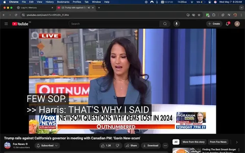 The image shows a scene from a live broadcast on Fox News, featuring a woman speaking into a microphone. She has long, dark hair styled in loose waves and is wearing a light blue blazer over a black top. Around her neck, she has a delicate chain with a small cross pendant. The woman appears to be engaged in conversation, with her mouth open as if she is speaking.

In the background, there is a bright orange construction barrier with the word "OUTNUMBERED" prominently displayed in white letters. The setting appears to be an urban environment, as indicated by the street signs and buildings visible behind her. There are traffic signs, including a speed limit sign, and some blurred figures of people walking in the background.

The lower part of the image contains a banner with the Fox News logo and the text "NEWSOM QUESTIONS WHY DEMS LOST IN 2024." The word "LIVE" is highlighted in red at the top left corner of the screen, indicating that this is a live broadcast.

The overall atmosphere suggests a news segment focused on political commentary, with the woman likely discussing current events related to the Democratic Party and its performance in the 2024 elections. The image captures a moment of active dialogue, emphasizing the dynamic nature of live television reporting.