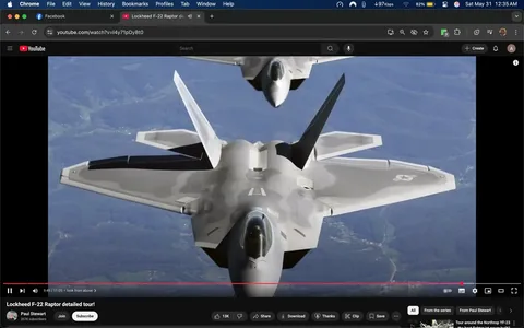 The image depicts two Lockheed F-22 Raptor fighter jets flying in formation against a backdrop of mountainous terrain. The aircraft are shown from a slightly elevated angle, with the foreground jet prominently displayed while the second jet is positioned slightly above and behind it.

**Details of the Aircraft:**
- The leading F-22 has a sleek, angular design typical of modern stealth fighters, characterized by its sharp edges and smooth surfaces.
- The color scheme is primarily a light gray with darker gray accents, enhancing its stealth capabilities.
- The wings are swept back, and the aircraft features distinctive vertical stabilizers that are angled outward.
- The cockpit is visible, showcasing a dark canopy that reflects some light, indicating the presence of a pilot inside.
- The underside of the wings has a black section, possibly housing weaponry or fuel tanks.
- The tail section of the aircraft displays a logo, which appears to be a stylized representation of a bird or eagle, indicative of military insignia.

**Background:**
- The background consists of rolling hills and mountains, with a mix of green vegetation and rocky terrain. The sky is clear, suggesting good flying conditions.
- There are no visible signs of human activity or structures in the background, emphasizing the natural landscape.

**Text and Branding:**
- The image includes a YouTube interface at the bottom, indicating that this is a video still. The title "Lockheed F-22 Raptor detailed tour!" is visible, along with the channel name "Paul Stewart" and subscriber count.
- There are playback controls visible at the bottom of the image, including buttons for play, pause, and volume adjustment.

Overall, the image captures a moment of aerial display featuring advanced military technology, set against a scenic backdrop, while also providing context through the YouTube interface.
