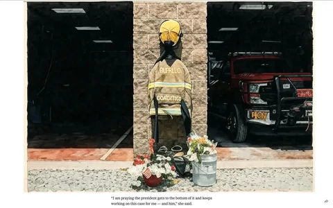 The image depicts a memorial for Corey Compertore, a former fire chief, situated in front of a fire station. The memorial features a firefighter's uniform, which includes a jacket and helmet. The jacket is hanging on a wall and has the word "BUFFALO" prominently displayed on the back, along with the name "COMPERTORE" below it. The helmet is yellow and is positioned above the jacket.

At the base of the memorial, there is a collection of flowers arranged in a bucket, with various colors including red, white, and blue, which may symbolize patriotism. Additionally, there are small American flags placed among the flowers. The memorial is set on a gravel surface, and the background shows a fire truck parked in a garage, partially visible through an open doorway. The truck is red and has the number "R-27" displayed on its front.

The lighting in the image appears bright, suggesting it was taken during the day. The wall behind the memorial is made of gray concrete blocks, and the overall setting conveys a somber yet respectful atmosphere. There are no visible people in the image, and the focus remains solely on the memorial and the fire truck.