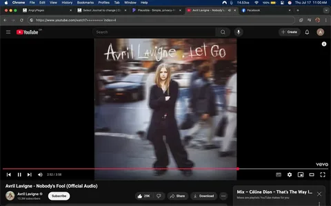 The image displays the album cover for Avril Lavigne's "Let Go," featuring a blurred background of a busy street scene. In the foreground, a young woman with long, straight blonde hair stands with her arms crossed, wearing a black outfit that includes a long coat and baggy pants. Her expression appears serious or contemplative, conveying a sense of defiance or independence. The text "Avril Lavigne" and "Let Go" is prominently displayed in a casual, handwritten style at the top of the image.

The background features indistinct figures walking, suggesting a bustling urban environment, with a car visible in the blurred background. The overall tone of the image evokes themes of youth, rebellion, and self-assertion, which align with Lavigne's pop-punk persona. There are no explicit or controversial elements, but the image captures a moment of introspection amidst chaos, reflecting the emotional depth of the music. The branding includes the YouTube logo and a view count, indicating its digital platform context.